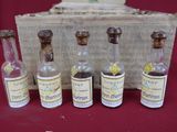 cinq petites bouteilles d'alcool devant une boîte