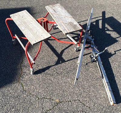 une table de pique-nique cassée, posée par terre sur le parking