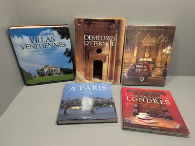 Quatre livres sont posés sur une table devant un mur blanc.