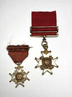 deux médailles et un ruban rouge sur un fond blanc