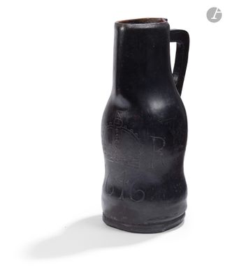 un vase noir posé sur une surface blanche