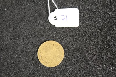 a gold coin and a tag on a black surface