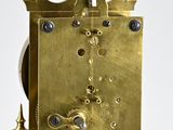 a gold clock that is sitting on a stand
