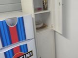 un réfrigérateur dans un coin d'une pièce, dont la porte est rayée de bleu et de rouge