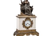 une petite horloge surmontée d'une statue