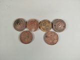 six different types of coins are arranged in a row on a table