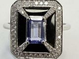 a close up of a ring with a blue stone surrounded by diamonds