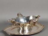 une assiette en argent ornée d'un oiseau en argent