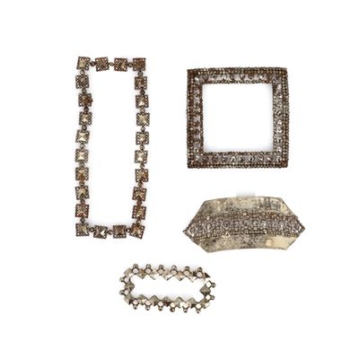 trois bijoux en argent posés sur une surface blanche