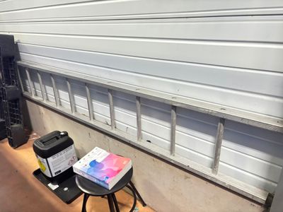 un petit tabouret sur lequel est posée une boîte, à côté d'une porte de garage