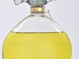 a bottle of perfume with a bird on top of it