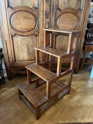 un tabouret en bois posé devant une armoire en bois