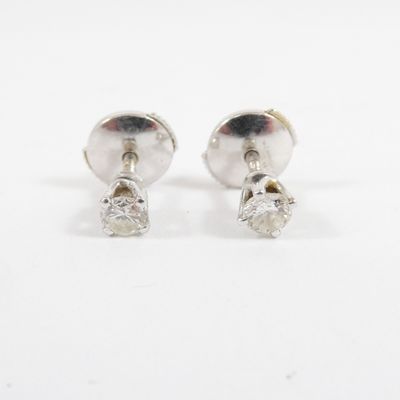 a pair of diamond stud earrings on a white background