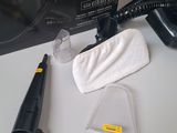 a black blow dryer sitting on a table next to a cleaning cloth