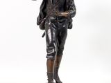 statue en bronze représentant un garçon avec un oiseau sur l'épaule
