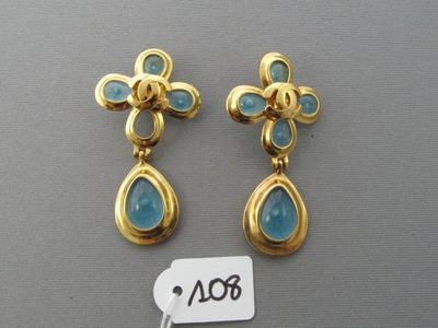 une paire de boucles d'oreilles en or et pierres bleues, avec son étiquette de prix
