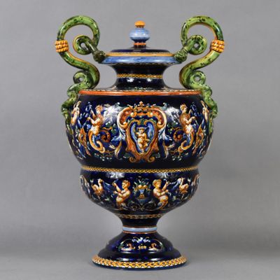 un vase bleu et vert muni de deux anses et posé sur un socle