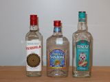 trois bouteilles d'alcool posées les unes à côté des autres sur une table