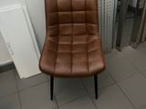a brown chair sitting in a bathroom next to a radiator