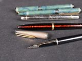 three pens sitting on a table next to each other