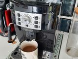 une cafetière posée sur un plan de travail, avec une tasse de café à côté