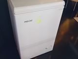 a small white refrigerator sitting on a table in a room