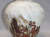 un vase blanc et marron posé sur une table