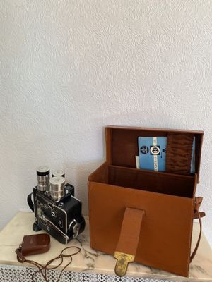 a box with a camera and a book on a table