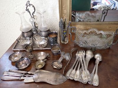 une table en bois sur laquelle sont posés de l'argenterie et un miroir
