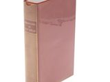 a pink book sitting on top of a white table next to a white wall