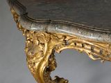 a marble topped table with a gold leafed base