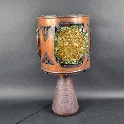 a small vase with a green and yellow decoration on it