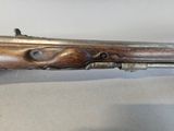a close up of a rifle with a wooden handle