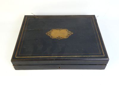 an old black box with a gold medallion on the lid