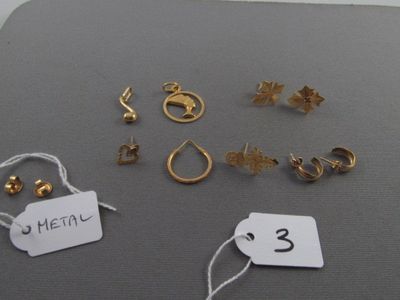 beaucoup de boucles d'oreilles en or et de pendentifs posés sur une table
