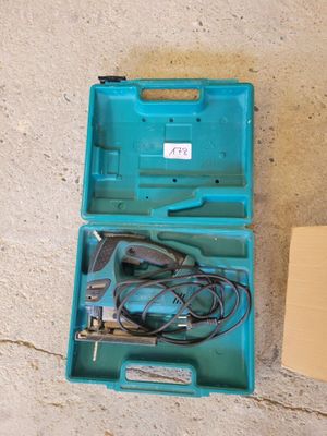 une boîte à outils bleue contenant des outils, posée par terre