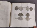 someone is holding a book with a bunch of drawings on it