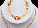 un gros plan d'un collier et d'un bracelet posés sur une assiette blanche