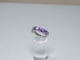 a ring with a purple stone on top of a clear glass