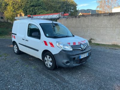 La camionnette blanche est garée sur le parking, près d'un mur.