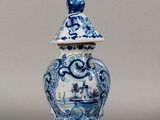 un vase bleu et blanc surmonté d'un oiseau