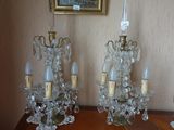 deux lustres en cristal posés sur une table, avec un tableau en arrière-plan