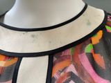 an image of a mannequin wearing a colorful dress with a black collar