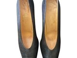 the woman ' s shoes are made of black leather and are on a white background