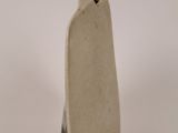a small white vase with a black handle on a white surface