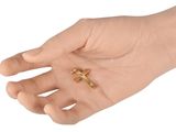a small gold cross on the palm of a person
