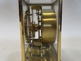 a gold clock that is sitting in a glass case