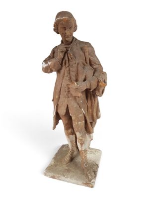 an old statue of a man with a hat and a coat