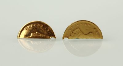 une paire de boucles d'oreilles en or avec une pièce au milieu
