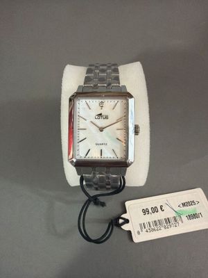 quelqu'un porte une montre au poignet, sur laquelle est accrochée une étiquette indiquant le prix